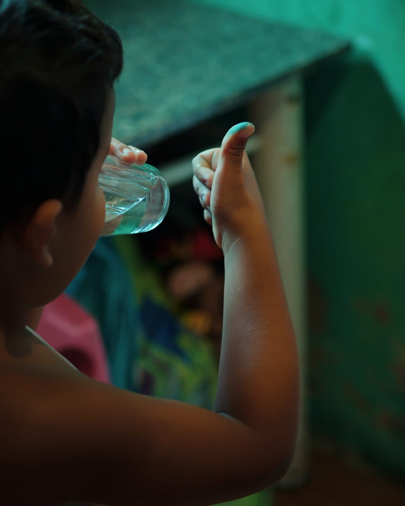 Criança bebendo um copo de água limpa